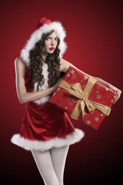 Santa claus girl with huge red gift box Royalty Free Stock Images