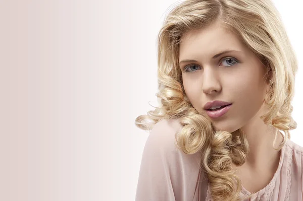 Blond ung tjej med lockigt hår och vackra ansikte ser på t — Stockfoto