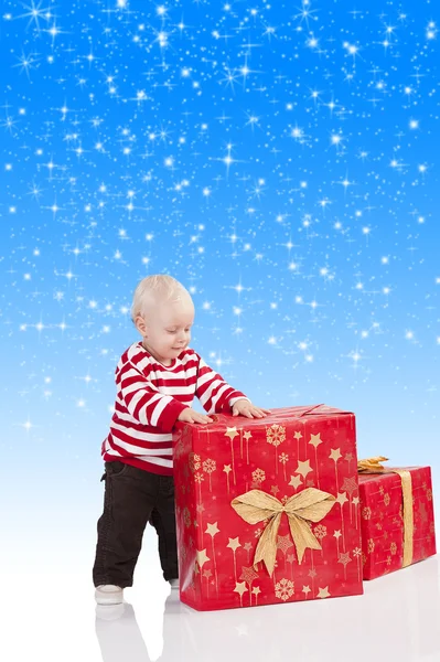 Niño de Navidad con caja de regalo, tiene sus manos en el gi grande —  Fotos de Stock
