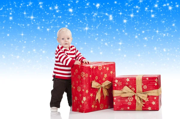 Bébé garçon de Noël avec boîte cadeau, il se tient debout et regarde dans — Photo