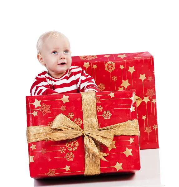Niño de Navidad con caja de regalo, bebé está sentado —  Fotos de Stock