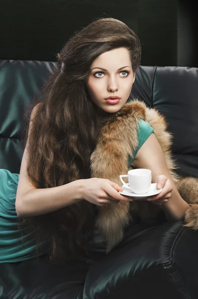 Young elegant girl in green with cup. she is looks at the left — Stock Photo, Image