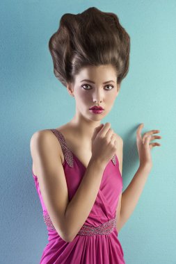 Young pretty model dressed in pink and with haute couture hair s clipart