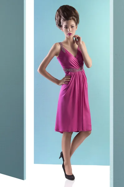 Csinos, fiatal nő, rózsaszín ruha és frizura divat — Stock Fotó