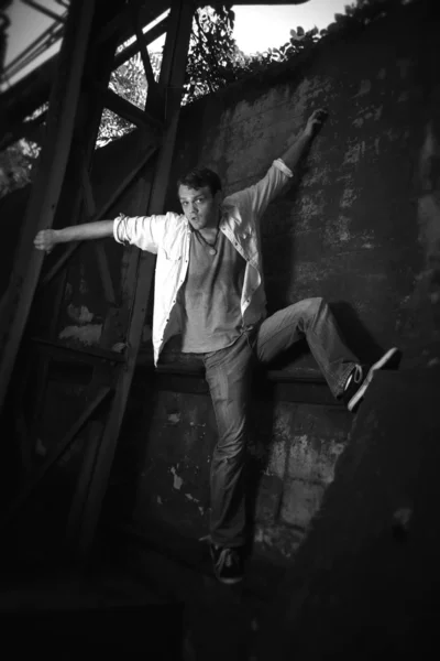 Schwarz-Weiß-Foto eines Mannes, der eine Wand hochklettert — Stockfoto