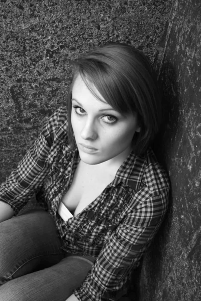 Молодая женщина, сидящая в углу — стоковое фото
