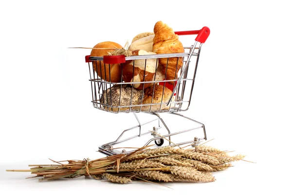 Bochník chleba a housky v nákupním košíku — Stock fotografie