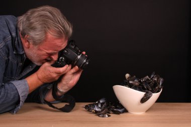 Mavi midye ile iş yerinde erkek fotoğrafçı