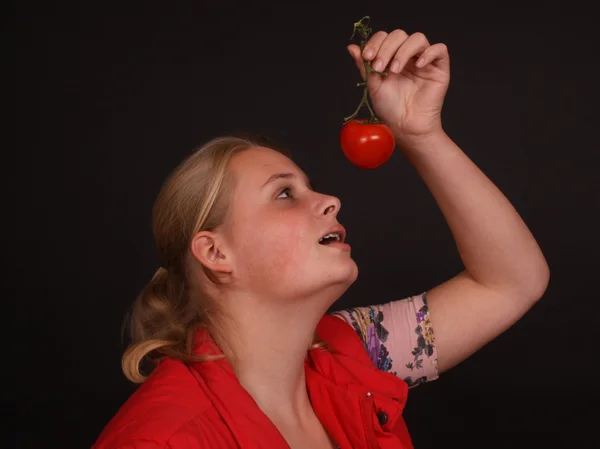 Young woman eating tomato — Stock Photo, Image
