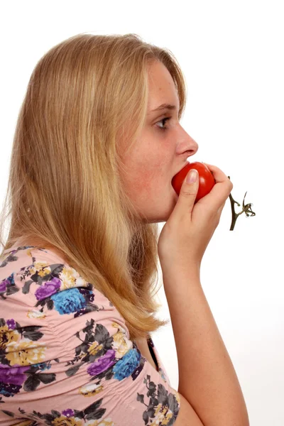 Mladá žena jíst rajčata — Stock fotografie