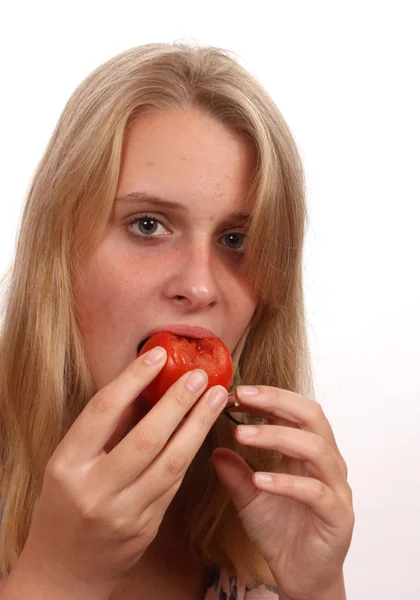 Jovem mulher comendo tomate — Fotografia de Stock
