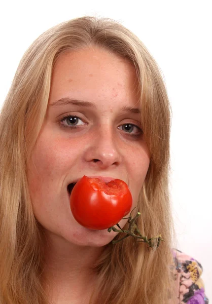 Молодая женщина ест помидоры — стоковое фото