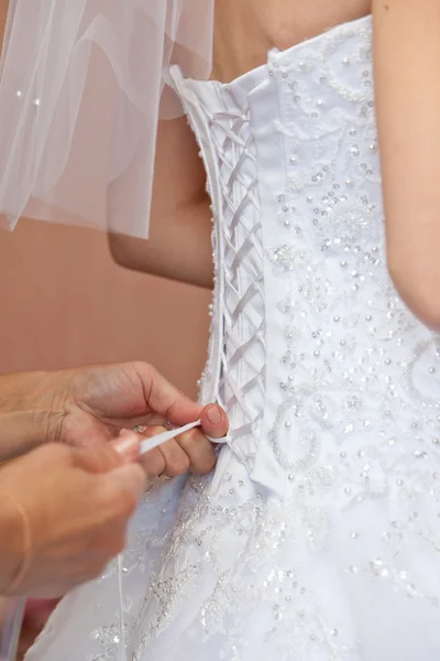 Robe de mariée laçage sur la mariée — Photo