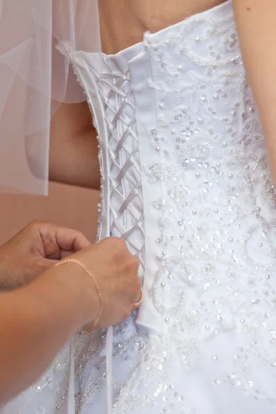 Bröllopsklänning snörning på bruden — Stockfoto