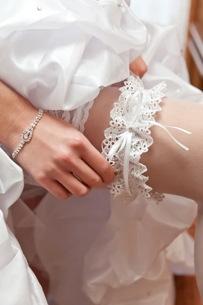 Jarretière blanche sur un pied de la mariée — Photo