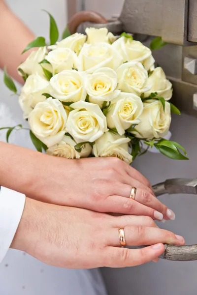 Vigselringar på en hand med brudgummen och bruden — Stockfoto