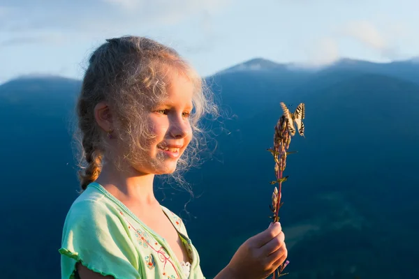 Chica y mariposa en la montaña puesta del sol —  Fotos de Stock