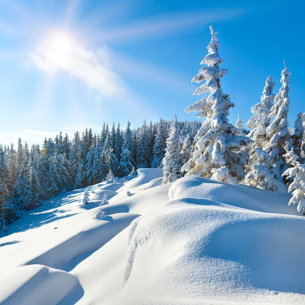 Snowdrifts on winter snow covered mountainside and sun — Stock Photo, Image