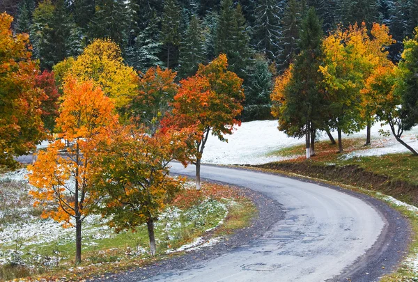 Primera nieve de invierno y follaje colorido otoño cerca de camino de montaña —  Fotos de Stock