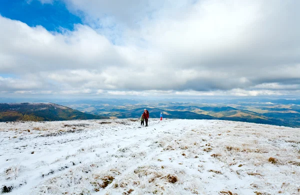 家族最初の冬の雪の秋の山高原の上を歩く — ストック写真