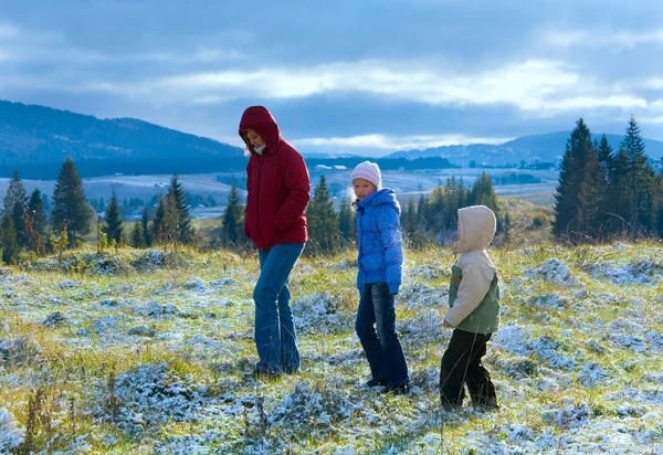 Первая зима снег в осенних горах и семья на прогулке — стоковое фото