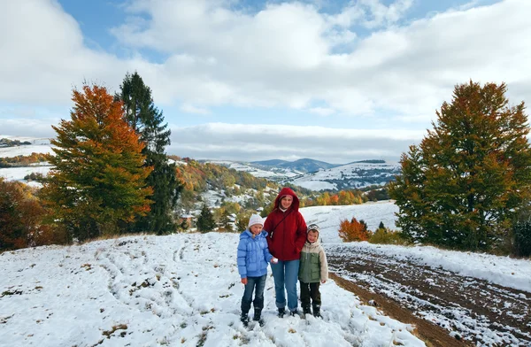 First winter snow in autumn mountain and family on walk — Stock Photo, Image
