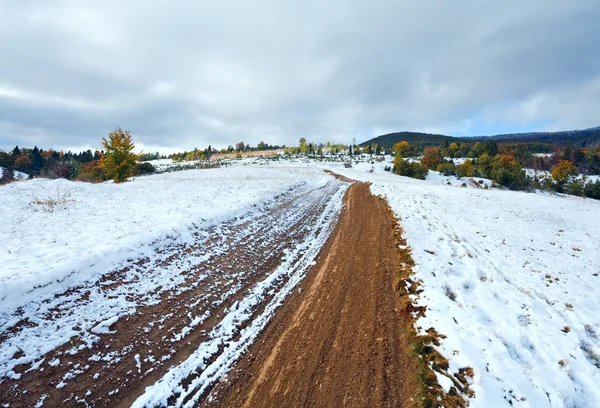 Az első téli hó őszi hegyi piszkos úton — Stock Fotó