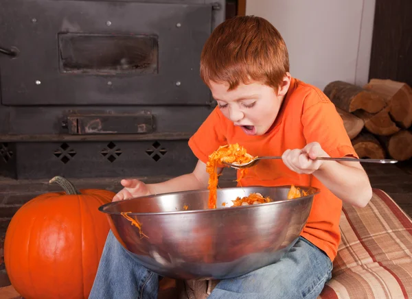 Young boy eating pumpkins — Stock Photo, Image