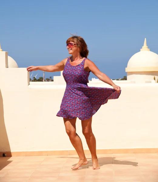 Alter spielt keine Rolle - gebräunte, fitte Frau mittleren Alters tanzt auf dem — Stockfoto