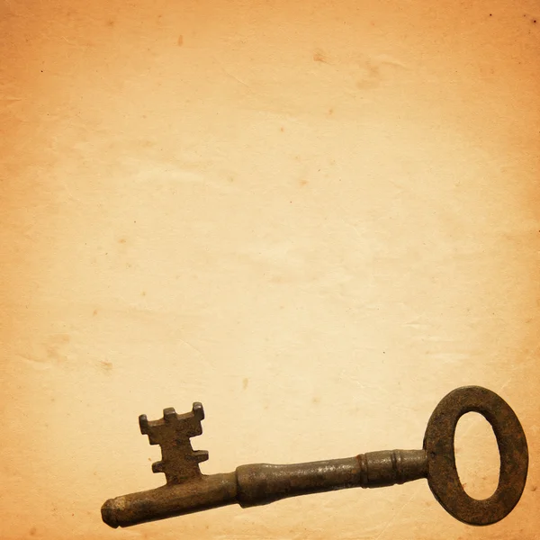 Старый бумажный фон со старым ключом — стоковое фото