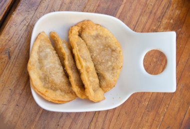 tuna hamur işleri (empanadas), ahşap bir masa üzerinde bir kısmını