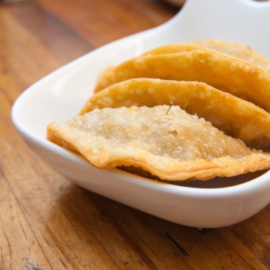 tuna hamur işleri (empanadas), ahşap bir masa üzerinde bir kısmını