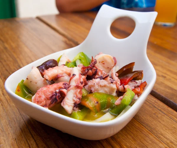 Gedeelte van octopus salade op een houten tafel — Stockfoto
