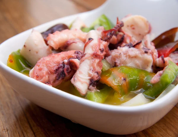 Gedeelte van octopus salade op een houten tafel — Stockfoto