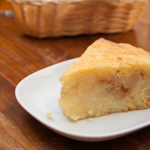 stock image Portion of tortilla (Spanish omelette) on a wooden table