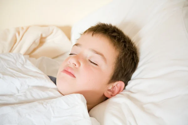 Az ágyában alszik a kis aranyos fiú — Stock Fotó