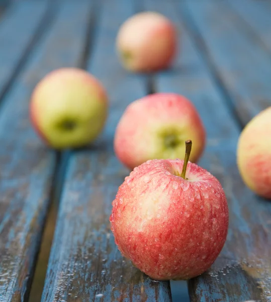 Feuchte rote Äpfel auf einem Gartentisch — Stockfoto