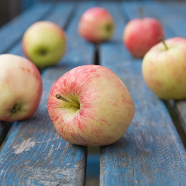 Mokry czerwone jabłka na stół ogrodowy — Zdjęcie stockowe