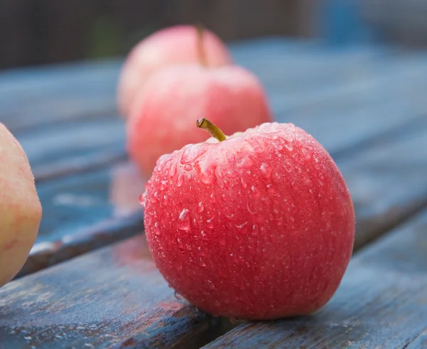 Mele rosse umide su un tavolo da giardino — Foto Stock
