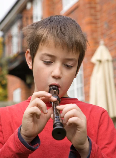 Young boy playing a recorder outside — Stock Photo, Image