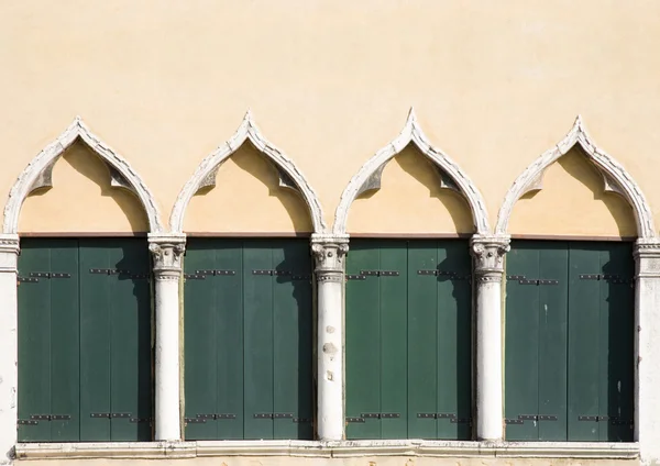 Detalhe arquitetônico - janelas arqueadas com persianas de madeira verde — Fotografia de Stock