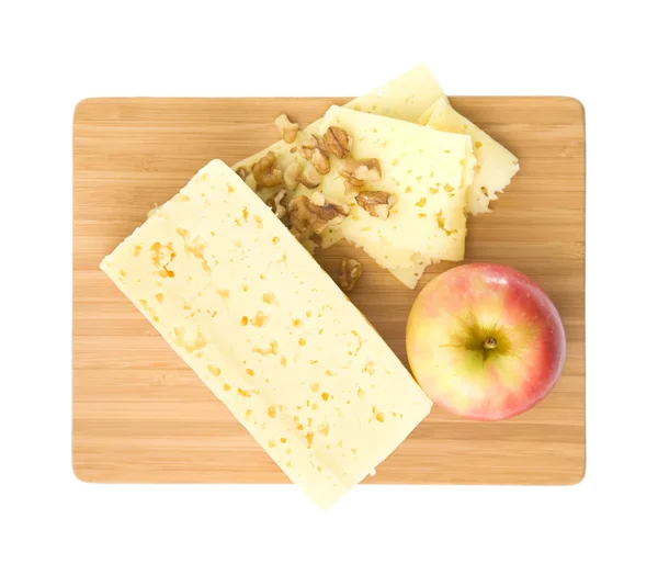 Здоровые закуски - ломтики сыра, грецкого ореха и красного яблока, представленные на дереве — стоковое фото