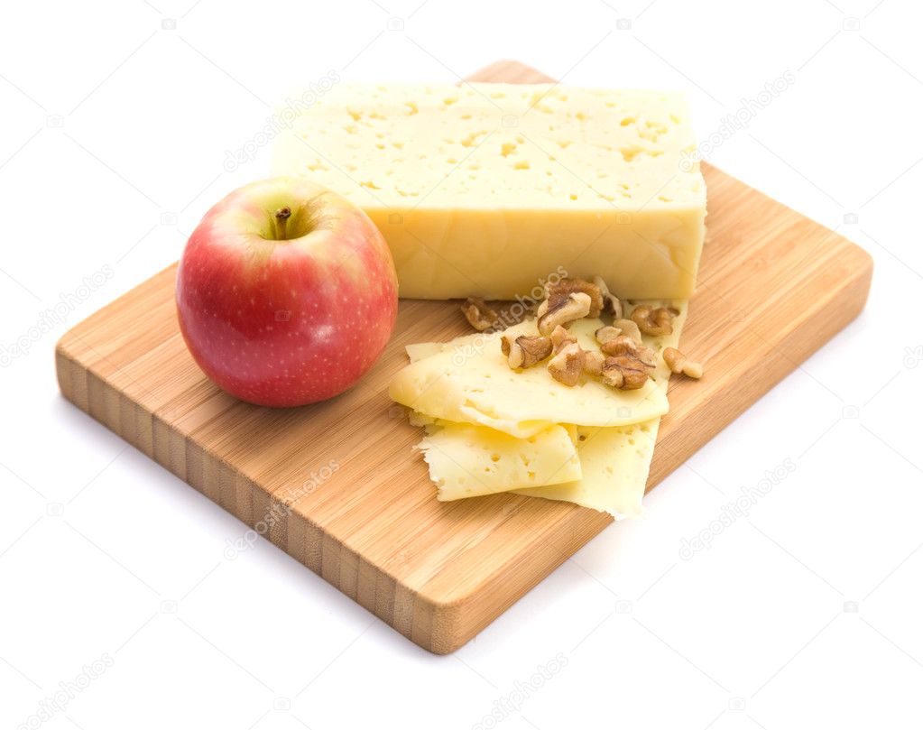 Healthy snack - slices of cheese, walnut and red apple presented on a woode
