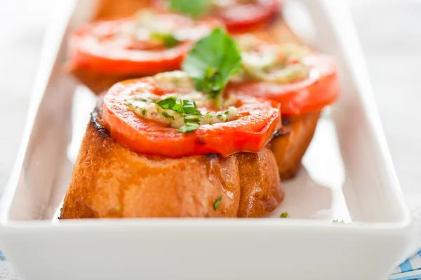 Bruschetta - guld bakade baguetter med tomat vitlök och basilika som — Stockfoto