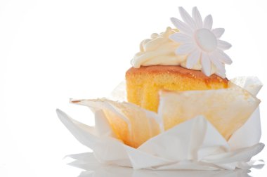 Cupcake with vanilla cream and sugar flower on a white backgroun clipart