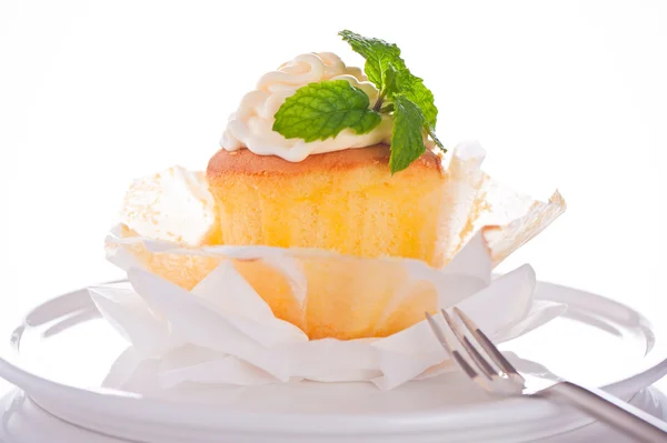 Cupcake con crema de vainilla y hoja de menta sobre fondo blanco — Foto de Stock