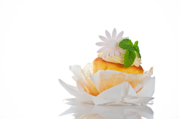 Cupcake com creme de baunilha folha de hortelã e flor de açúcar em um branco — Fotografia de Stock