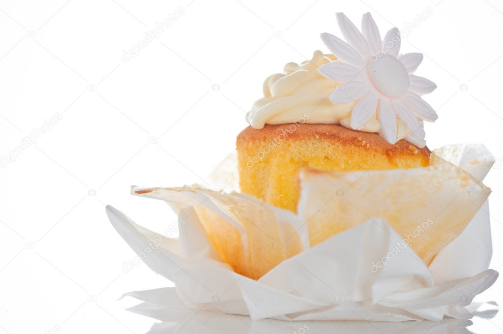 Cupcake with vanilla cream and sugar flower on a white backgroun