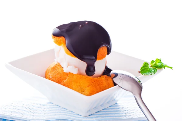 Profiterole en un tazón pequeño con salsa de chocolate helado y m —  Fotos de Stock