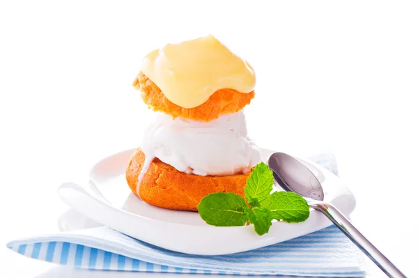 Профитерол в маленькой тарелке с ванильным соусом мороженого и ми — стоковое фото